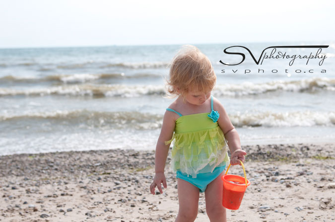 child-walking-with-bucket-on-beach