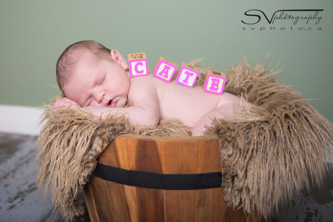 newborn with block letters on back