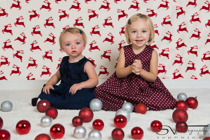 two sisters playing with christmas ornaments