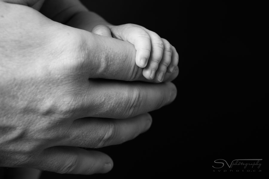 newborn baby holding daddy hand
