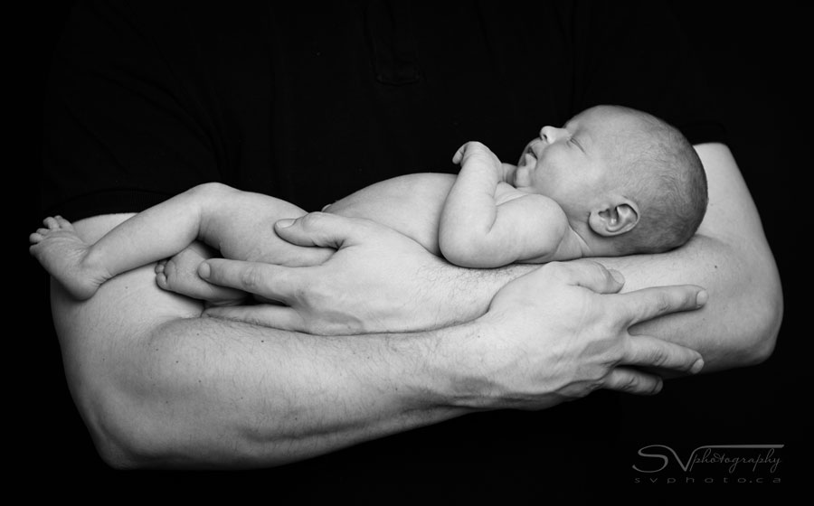 Portrait of newborn in fathers arms