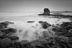 long exposure black and white rocks in ocean playa conchal