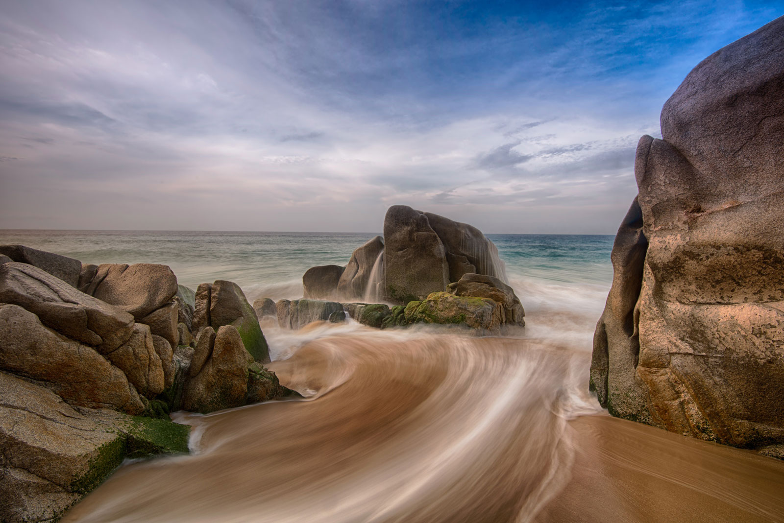 water rushes to the ocean between rocks in cabo san lucas mexico